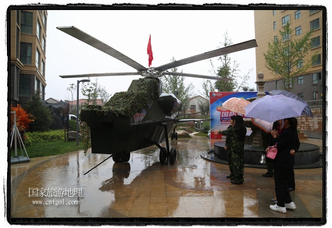 小區(qū)突然出現(xiàn)“飛機(jī)坦克”，其中殲15艦載戰(zhàn)斗機(jī)一架、99式主戰(zhàn)坦克一輛、武直-10武裝直升機(jī)一架，吸引了眾多市民雨中圍觀、合影。